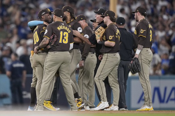 San Diego Padres left fielder Jurickson Profar, left, is held back by teammates after he protested with umpires when items were thrown at him in the outfield.