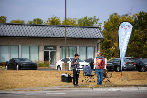 Anti-abortion protesters stand outside abortion clinic.