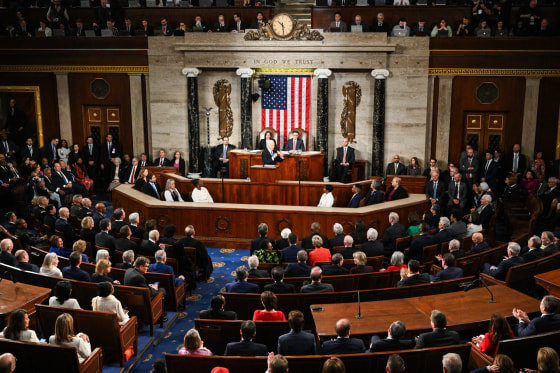 House members seated inside of the House Chamber room, Joe Biden speaks at the podium in the center