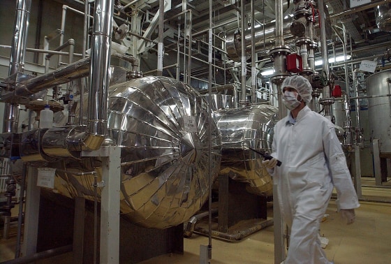 A security official in protective clothing walks inside a facility