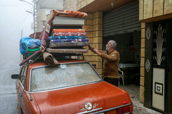 A resident unloads personal belongings from his car.