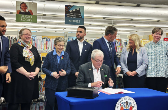 New Jersey Gov. Phil Murphy signs legislation aimed at barring public libraries and schools from banning books on Monday, Dec. 9, 2024, at the Princeton Public Library.