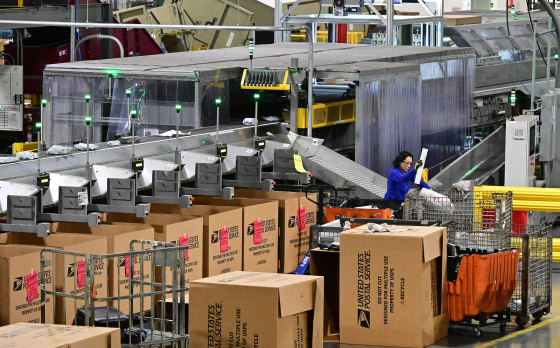 A postal workers sorts through mail and packages at the Los Angeles Processing and Distribution Center