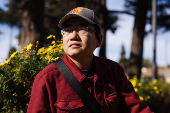 Bin Wei sits outside at a park