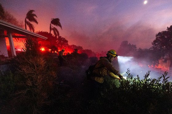 Firefighters work against a fast-moving wildfire on November 6, 2024 in Moorpark, Calif.