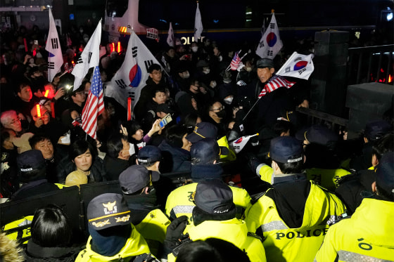 Police officers stand guard as supporters of impeached South Korean President Yoon Suk Yeol try to enter the Seoul Western District Court in Seoul, South Korea, on Sunday.