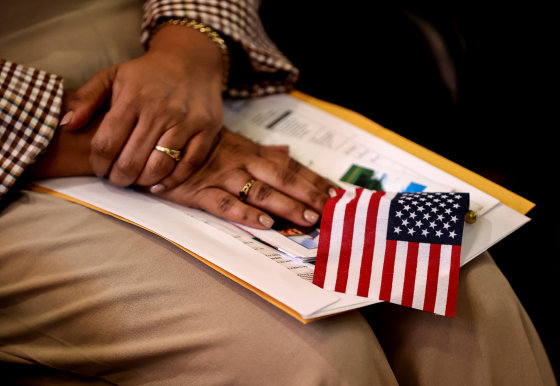 A new citizen holds an American flag during a naturalization ceremony 