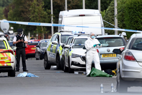 Police officers and forensic personnel behind a cordon in Southport, northwest England, on July 29, 2024, following a knife attack. 