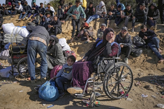 Displaced Palestinians gather with their belongings near a roadblock on al-Rashid Street as they wait to return to their homes in the northern part of the Gaza Strip on Sunday.