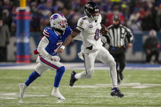 Lamar Jackson, right, and Taron Johnson run on the football field