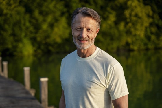 Happy senior man in white t-shirt near lake