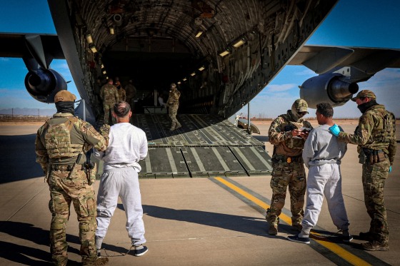 The first U.S. military aircraft to carry detained migrants to Guantanamo Bay is boarded from an unspecified location in the U.S.