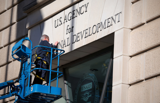 A worker removes the U.S. Agency for International Development sign on their headquarters on Feb. 7, 2025 in Washington.