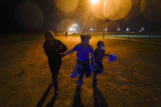 Three young migrants hold hands as they run to an intake area after turning themselves in upon crossing the U.S.-Mexico border in Roma, Texas, in 2021. 