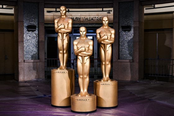 Oscar statues, lit by a spotlight, stand in front of the Dolby Theatre