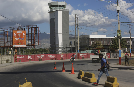 Pedestrians walk past Toussaint Louverture International Airport in Port-au-Prince, Haiti, in December.