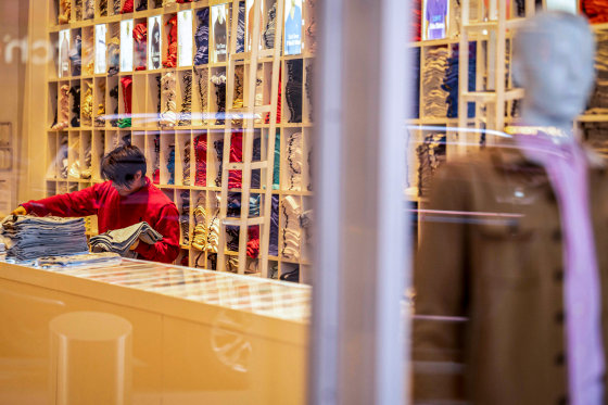 A retail worker seen from outside the store.