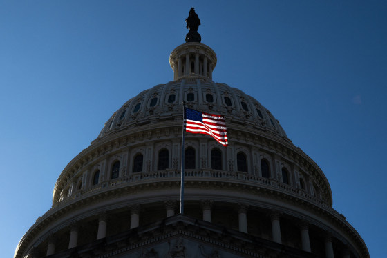 A U.S. flag flies in front of the dome of the Capitol.