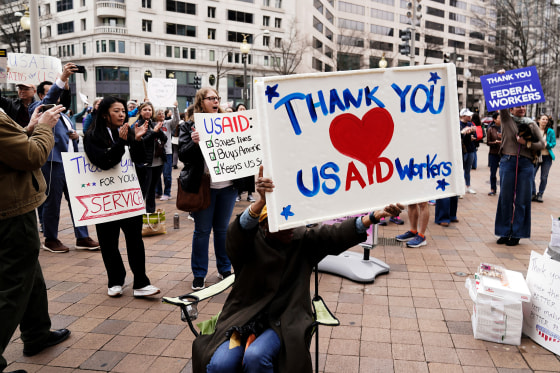A supporter holds a sign that reads, "Thank you USAID Workers"
