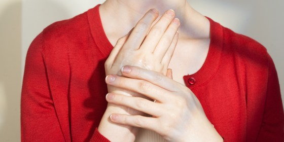 a woman wearing a red shirt, holding her hands