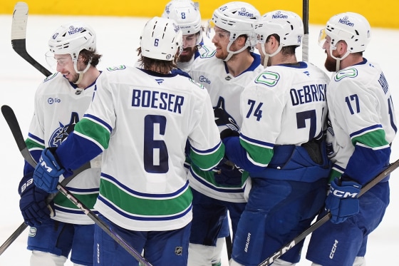 Players celebrate on the ice.