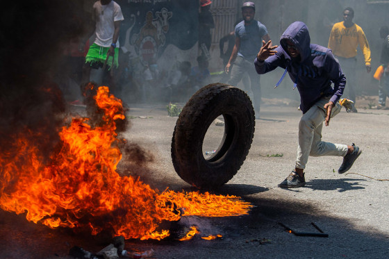A man throws a tire into a fire 