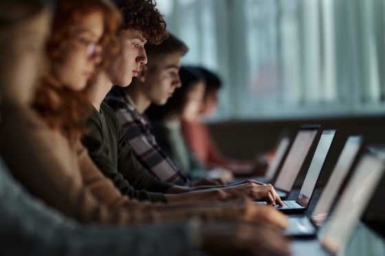 A group of students studying over laptops on a class at school. 