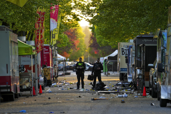 Police examine the scene where a vehicle drove into a crowd during a Filipino heritage festival in Vancouver
