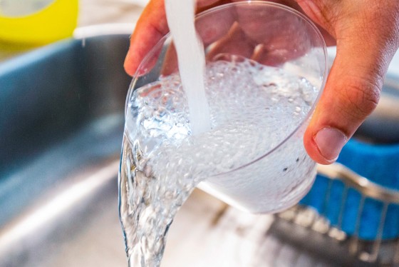 Tap water is poured into a cup from a faucet