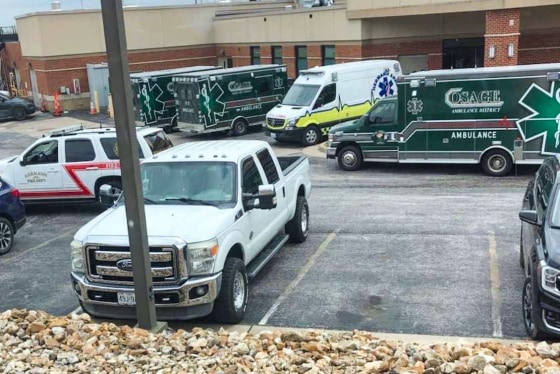 A parking lot with ambulances and cars