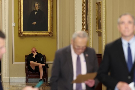 U.S. Senator Fetterman sits in the hallway behind the weekly Senate Democrat press conference at Capitol