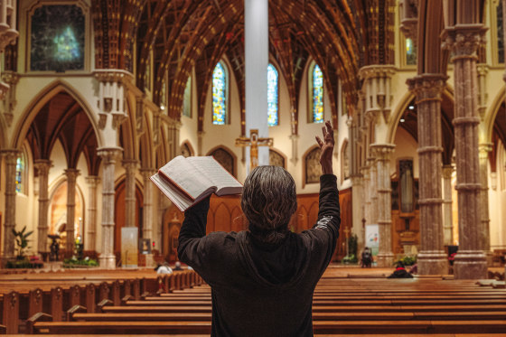 A person prays with their hands in the air