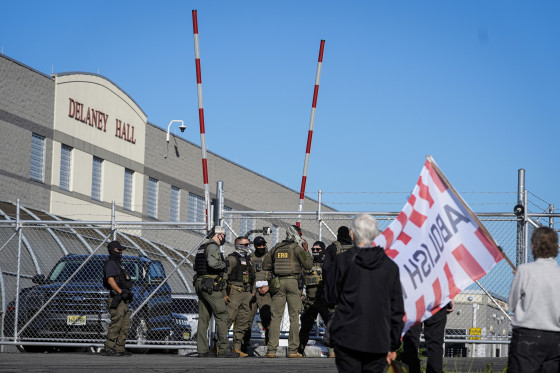 Protesters and security stand in front of Delaney Hall.