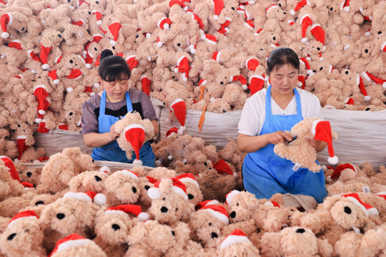 Employees produce Christmas stuffed toys for export at a toy factory