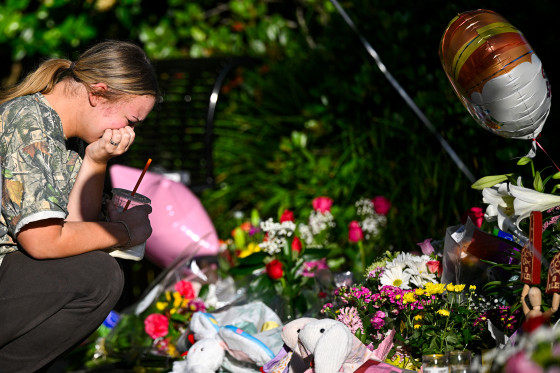 A person cries at a memorial