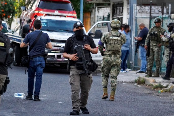 Members of the general prosecutor's office and the Navy stand guard near a vehicle involved in a shootout in Veracruz, Mexico.
