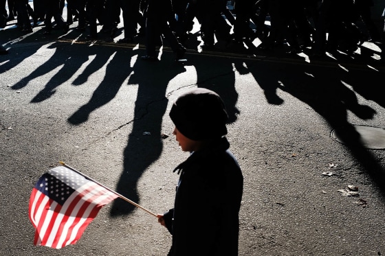 A child holds an American Flag as the Veterans Day Parade passes.