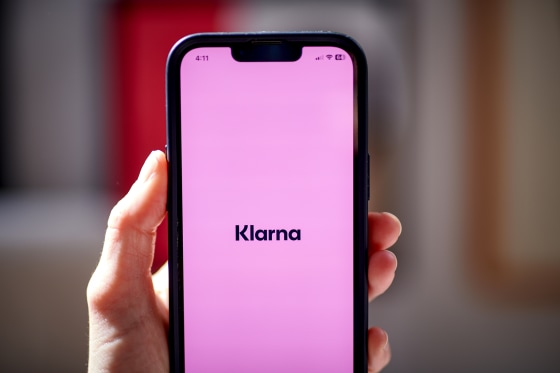 A person hols a phone with the Klarna app open.