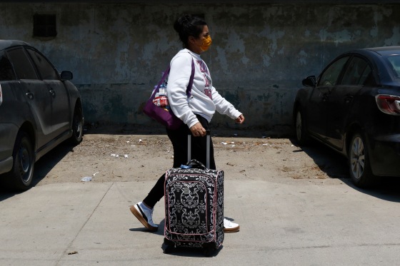 A Honduran migrant carries her luggage.