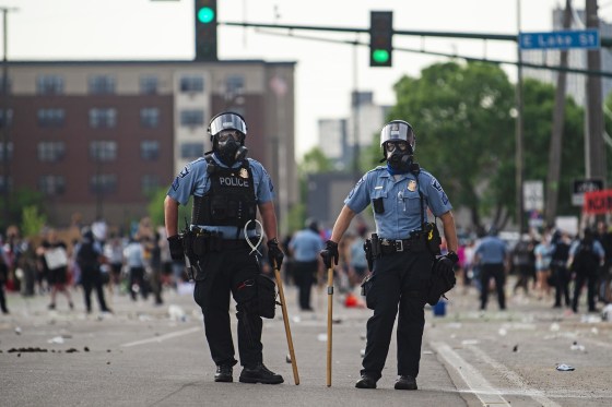 Two Minneapolis police officers stand outside the Third Police Precinct during ongoing protests after the death of George Floyd on May 27, 2020.