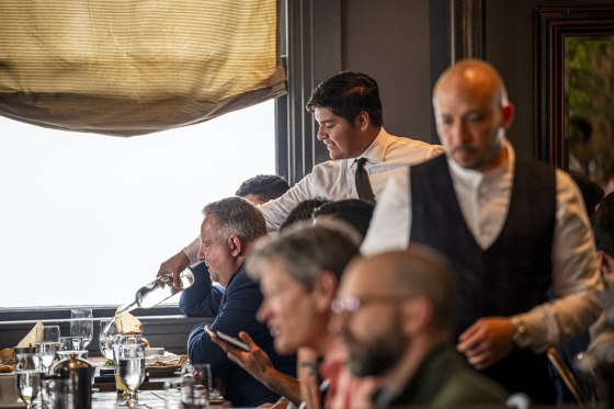 A server pours water at a restaurant.