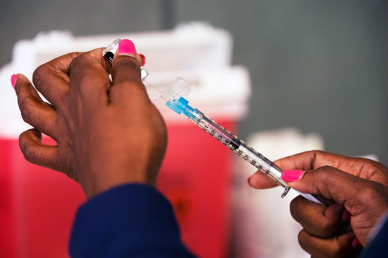 A staff member prepares a vaccine