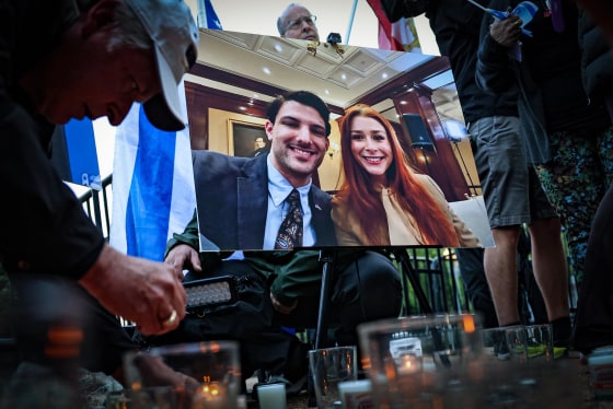 A photo of Yaron Lischinsky and Sarah Milgrim is displayed at a vigil outside the White House on May 22, 2025.