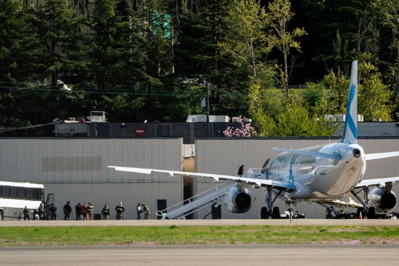 Detainees are transferred from buses to a plane chartered by U.S. Immigration and Customs Enforcement at King County International Airport in Seattle on April 15.
