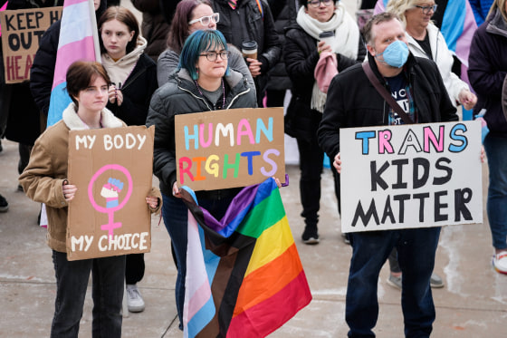 People gather in support of transgender youth during a rally outside