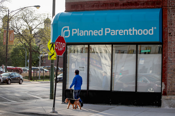 A person passes in front of a closed planned parenthood.