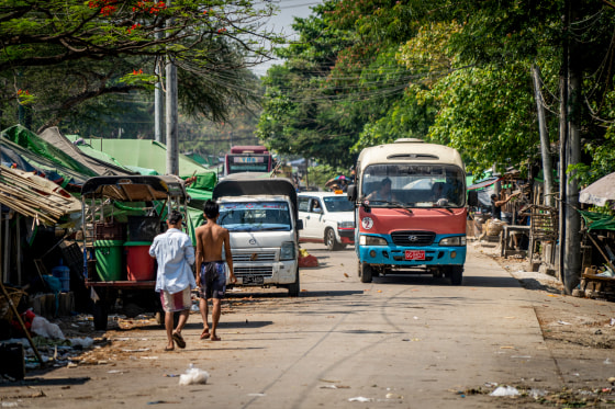 People walk down a rural road.