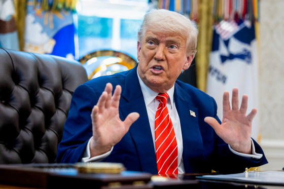 Donald Trump speaks while seated at his desk in the Oval Office