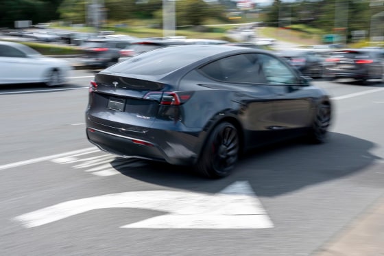 A Tesla Model Y vehicle drives near the company's store in Colma, Calif.