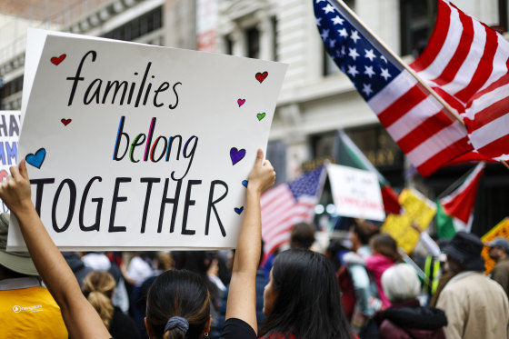 demonstrator carries a sign reading 'Families Belong Together.'